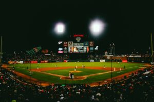 A baseball stadium at night lit up during a game